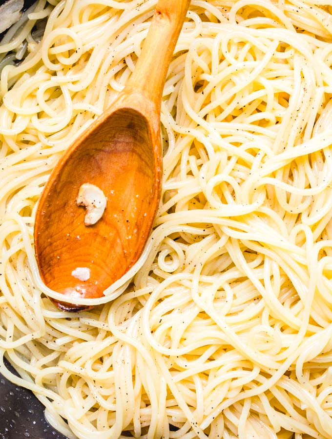 The spaghetti and garlic mixed together in the pan.