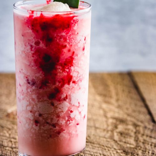 Raspberry Colada Cocktail with fresh pineapple and lime juice. A raspberry puree is added to the coconut milk and rum cocktail.