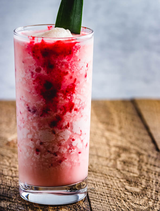 Raspberry Colada Cocktail with fresh pineapple and lime juice. A raspberry puree is added to the coconut milk and rum cocktail.