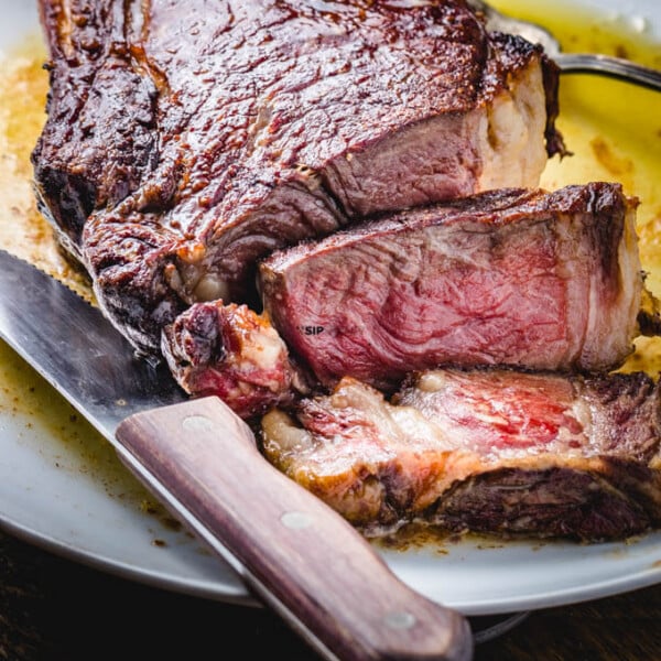 Ribeye steak cut up in plate with butter.