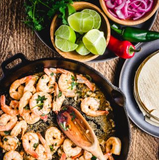 Shrimp taco recipe with limes, marinated red onions, tortillas, and cilantro.