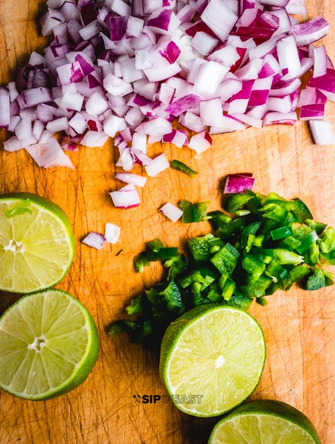 Halved limes, chopped jalapenos, and red onion.