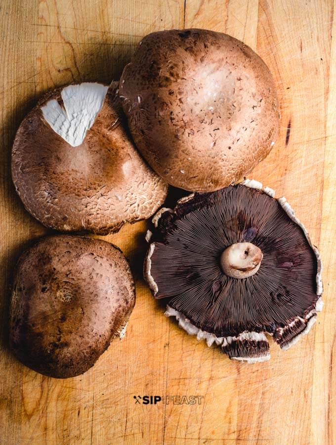 Portobello mushrooms on cutting board.