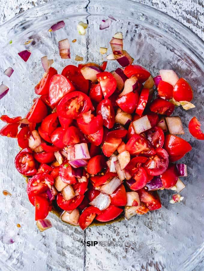 Chopped tomatoes and red onions in a bowl.