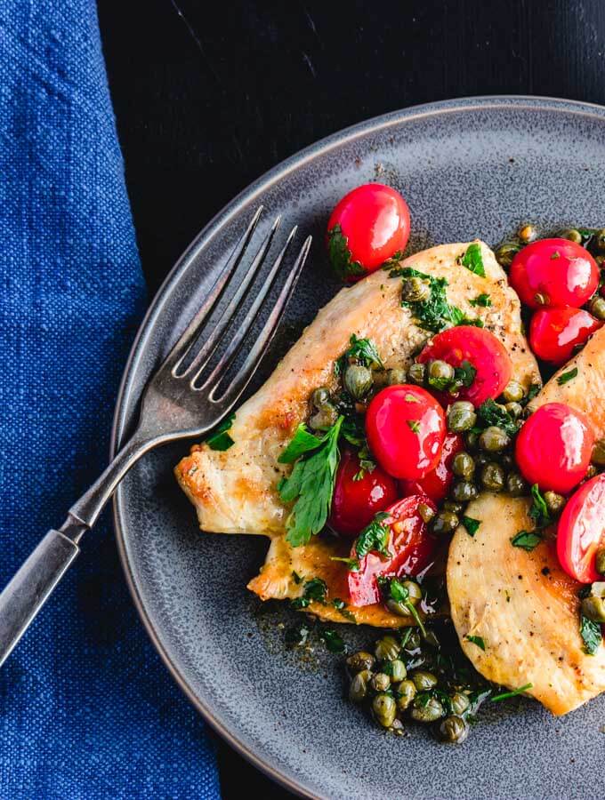  Italian chicken with capers and cherry tomato sauce plated.