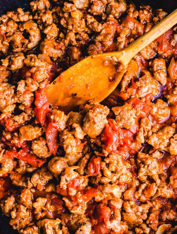 Sweet Italian sausage sauce in pan with tomatoes.