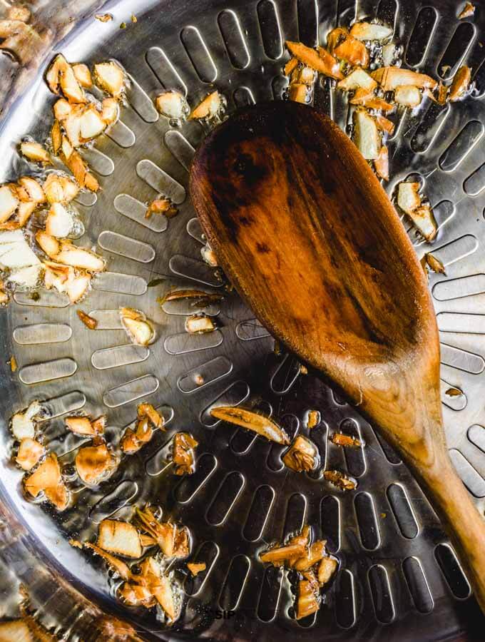 Sauteing garlic in pan with olive oil.