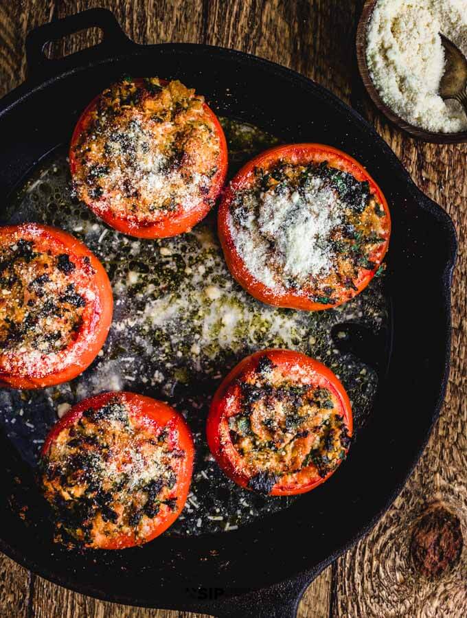 Easy stuffed tomatoes with ricotta salata and parsley overhead shot in cast iron pan.