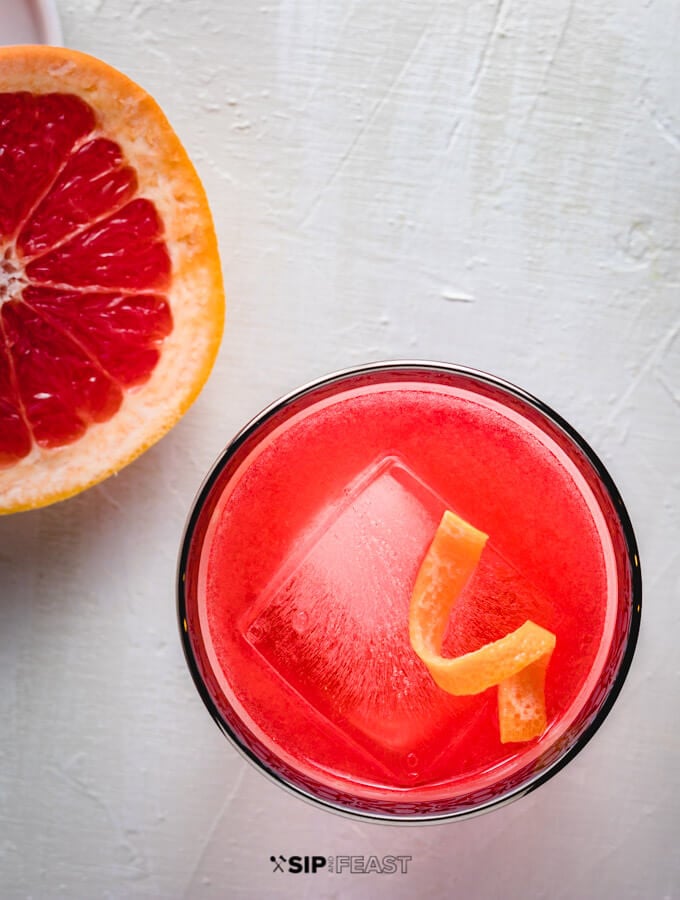 A glass of the grapefruit gin negroni with a twist of grapefruit peel