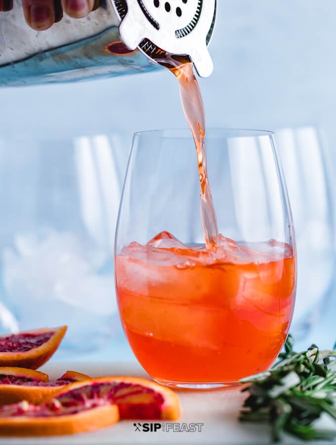 Aperol Spritz being poured into wine glass with ice.