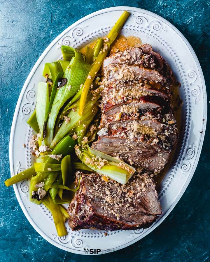 Pork In milk sliced and in platter with leeks.