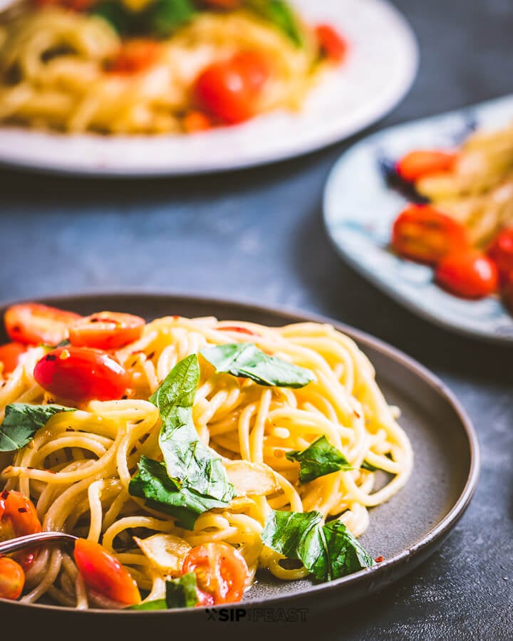 Three plates of spaghetti on blue setting.