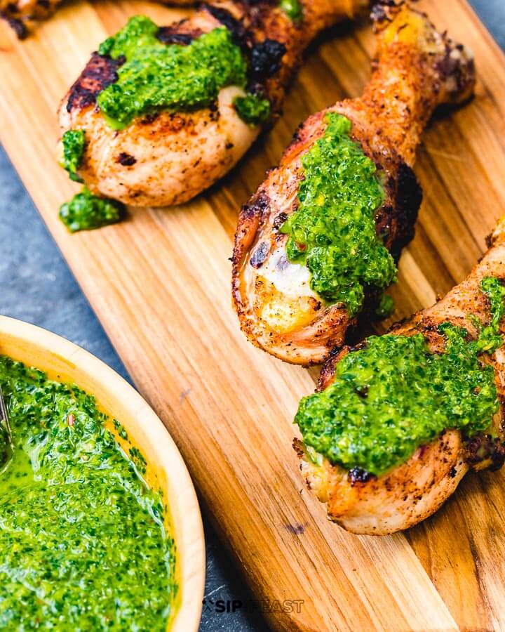 Italian green sauce on three chicken legs.