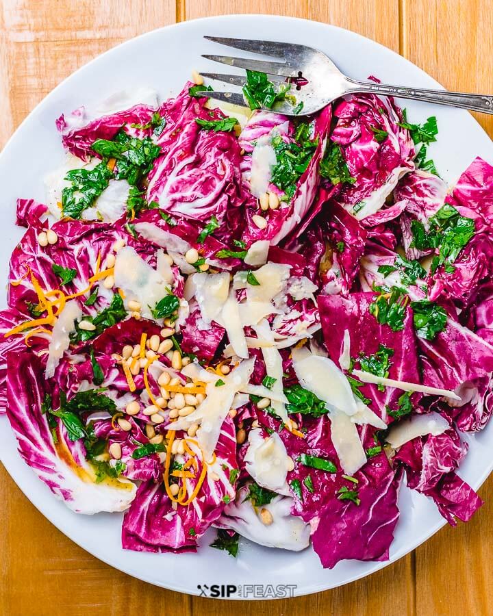 Radicchio salad in white plate on wood table.