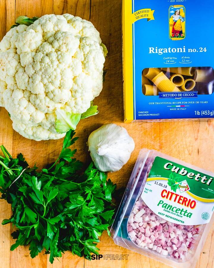 Ingredients shown: cauliflower, box of rigatoni, parsley, garlic and pancetta.