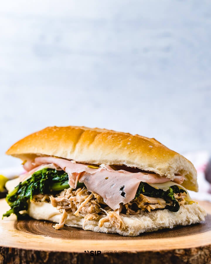 Italian pulled pork sandwich with mortadella on wooden board.