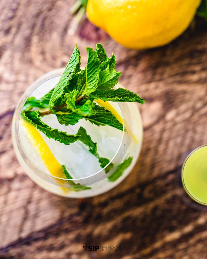 Top down view of a glass of limoncello spritz with mint garnish.