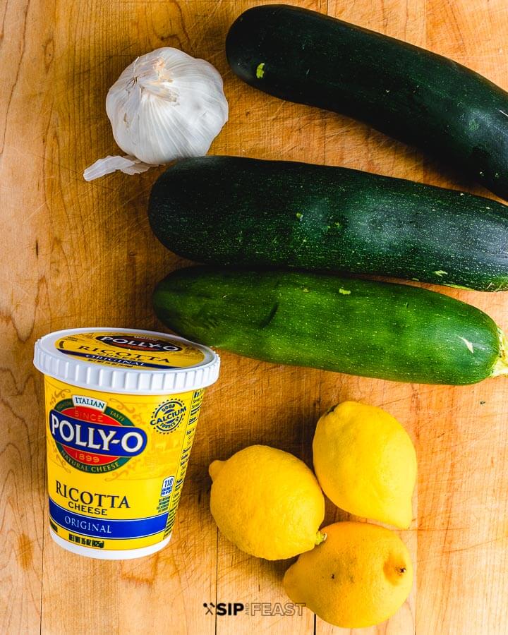 Ingredients shown on cutting board: garlic, 3 zucchini, ricotta and 3 lemons.