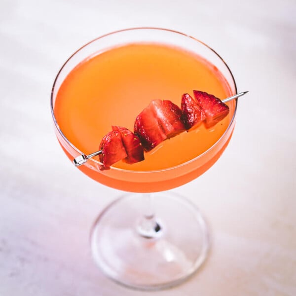 Strawberry lemonade vodka in glass with strawberry garnish.