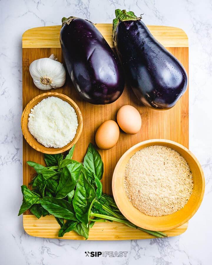 Ingredients shown: garlic, 2 eggplants, Pecorino Romano, 2 eggs, bunch of basil and breadcrumbs.