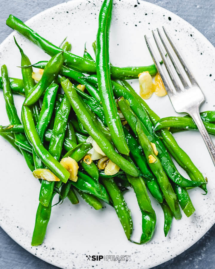 Garlic green beans on white plate.