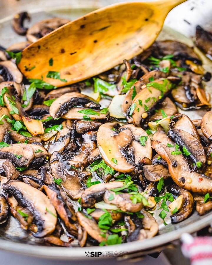 Closeup shot of garlic sauteed mushrooms in pan.