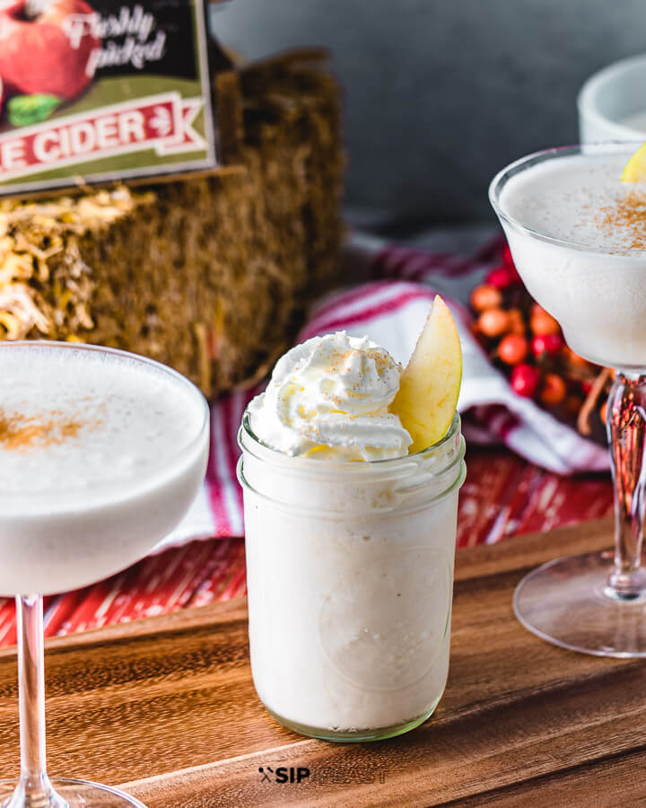 Coupe glasses filled with apple pie ala mode martini and a mason jar filled with apple pie ala mode mocktail.