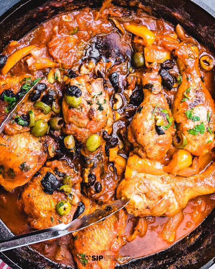 Overhead shot of chicken cacciatore in a cast iron pan.