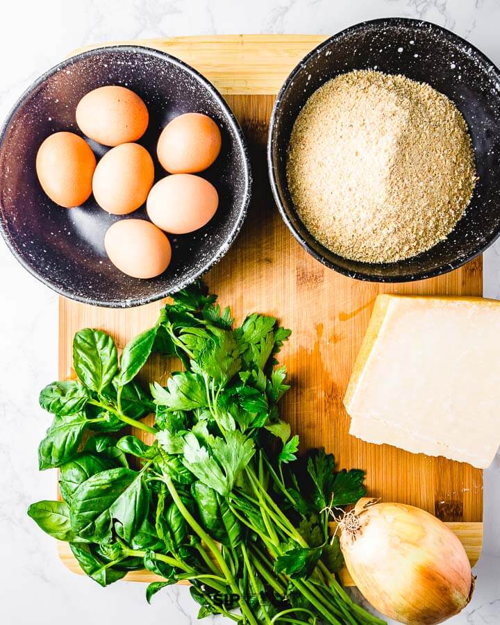 Ingredients shown: eggs, breadcrumbs, basil, parmesan cheese, and a large onion.