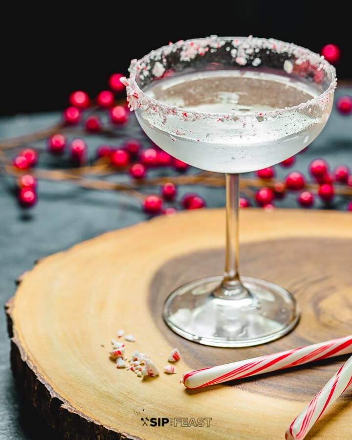 Candy Cane Cocktail with holly berries and candy canes in background