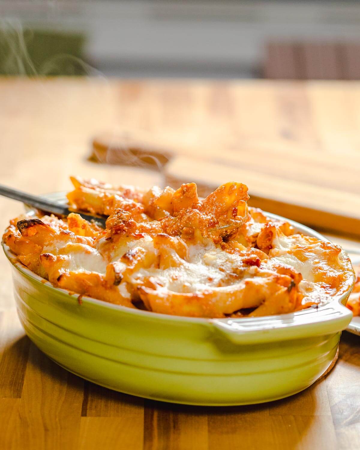 Baked pasta dish on table with steam rising from it.