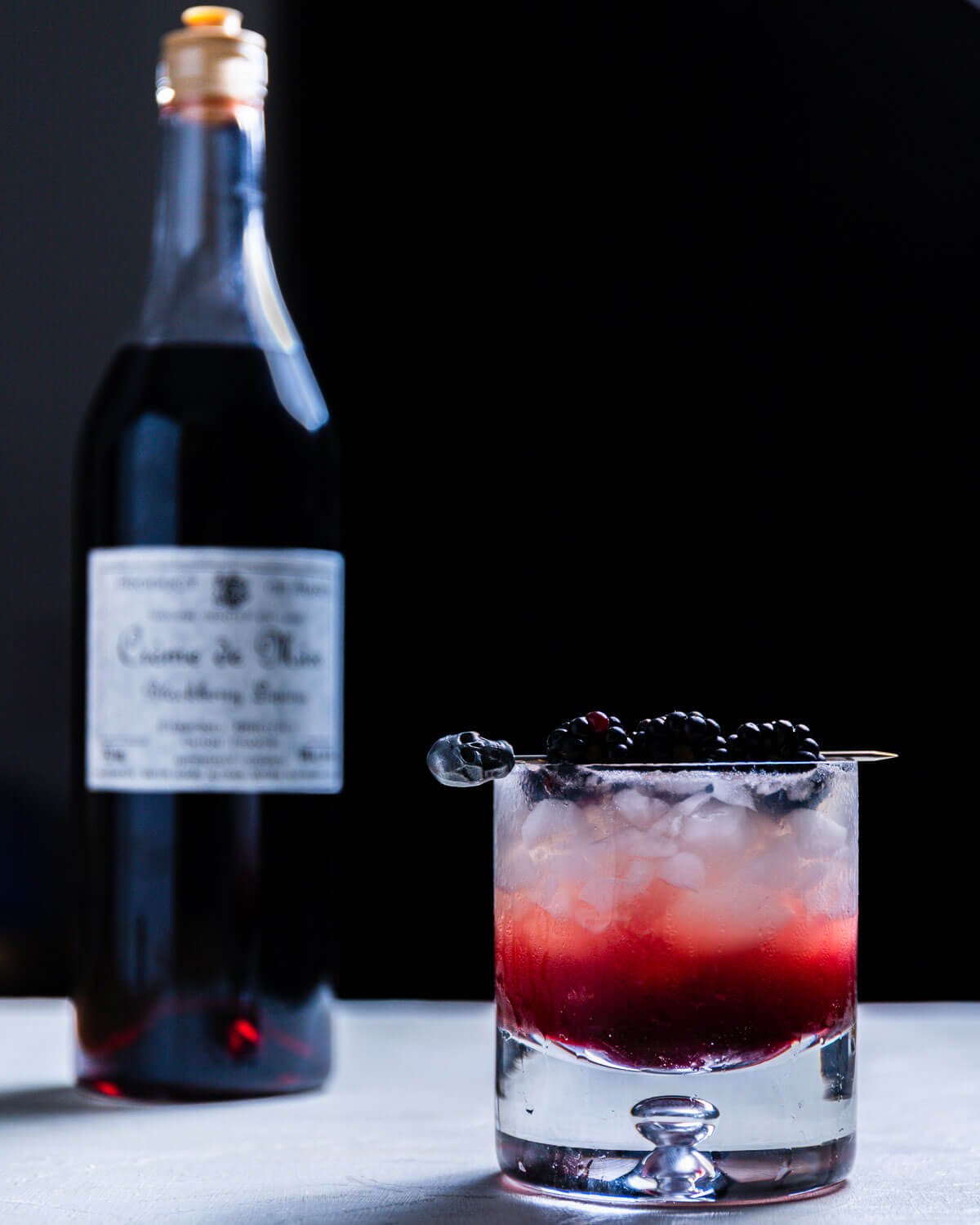 Blackberry Bramble in glass with 3 blackberries as garnish.