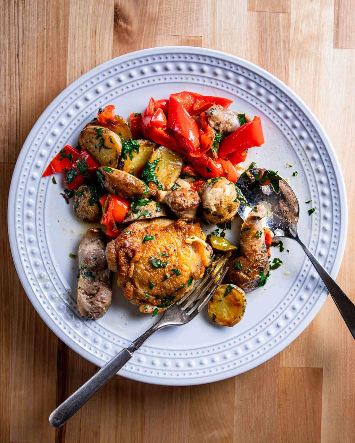 Overhead shot of Chicken Scarpariello in white plate.