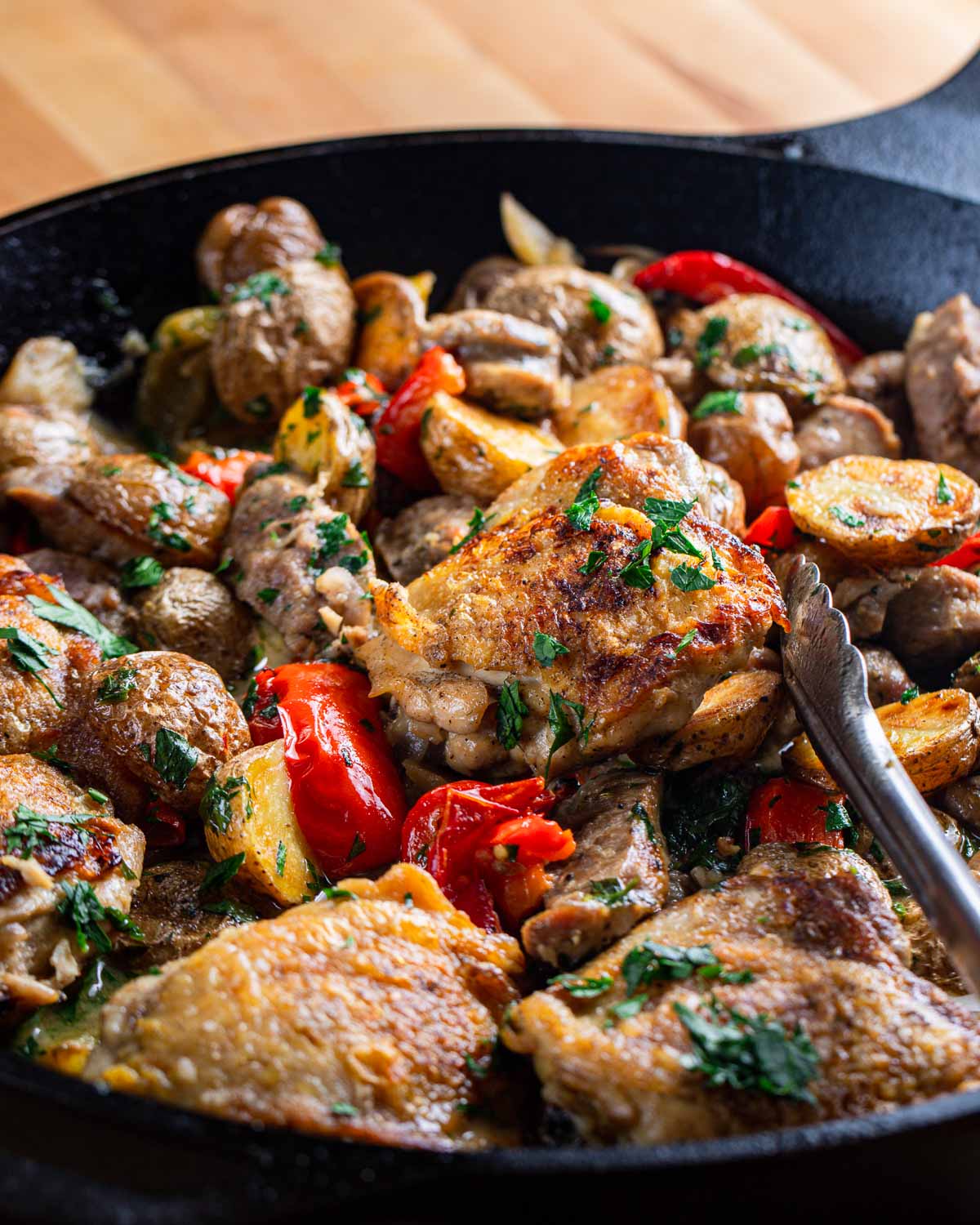 Chicken Scarpariello in large cast iron pan.