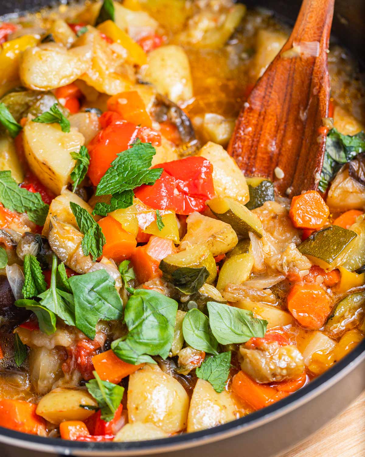 Large pan filled with ciambotta and topped with basil and mint.