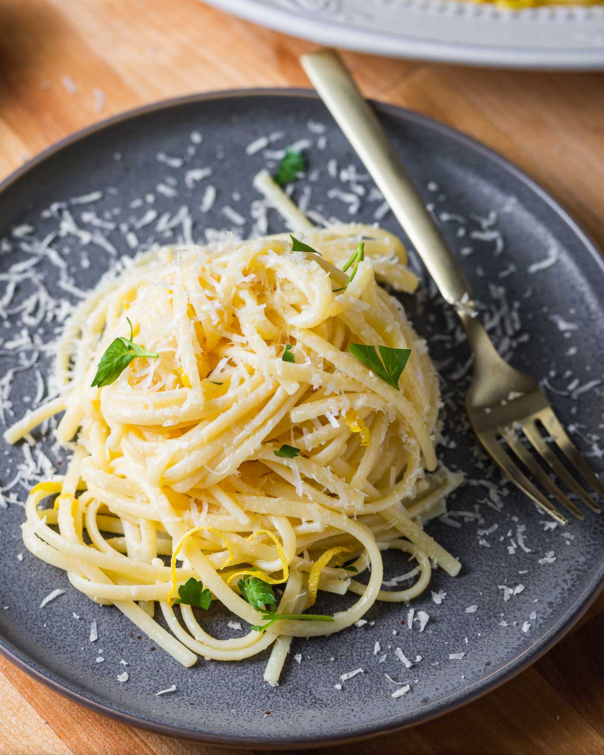 Linguine al limone in grey plate with sprinkled parsley.