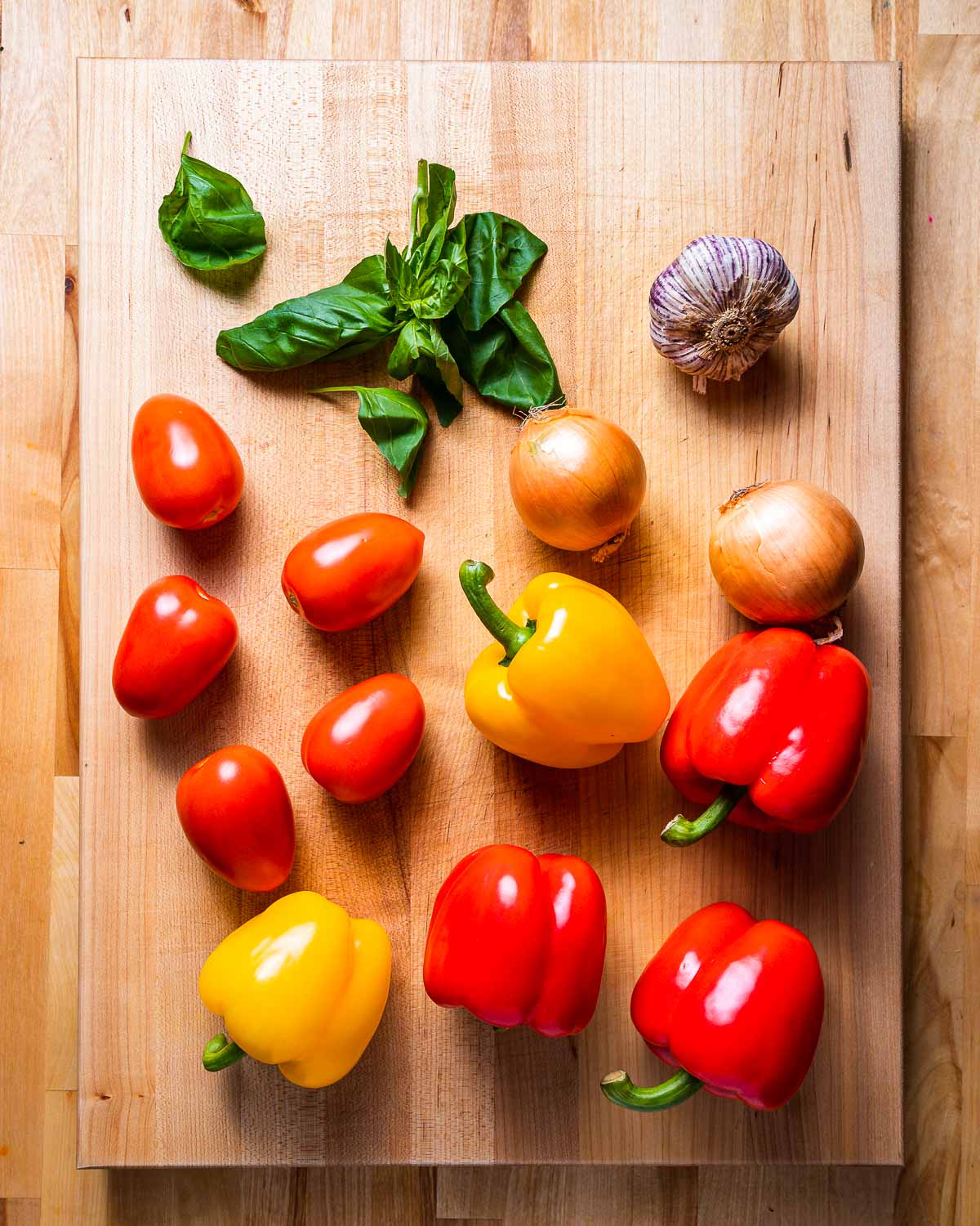 Ingredients shown: basil, garlic, tomatoes, onions, and bell peppers.