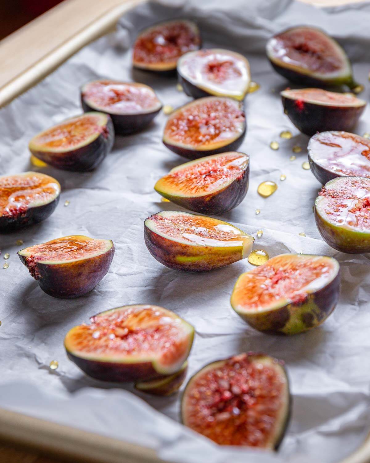 Cut figs on parchment paper lined baking sheet with drizzled honey.