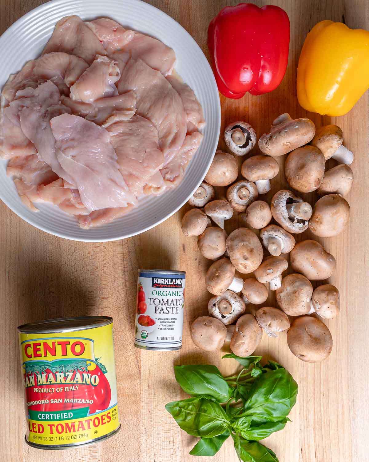 Ingredients shown: plate of chicken, peppers, canned tomatoes, mushrooms, and basil.
