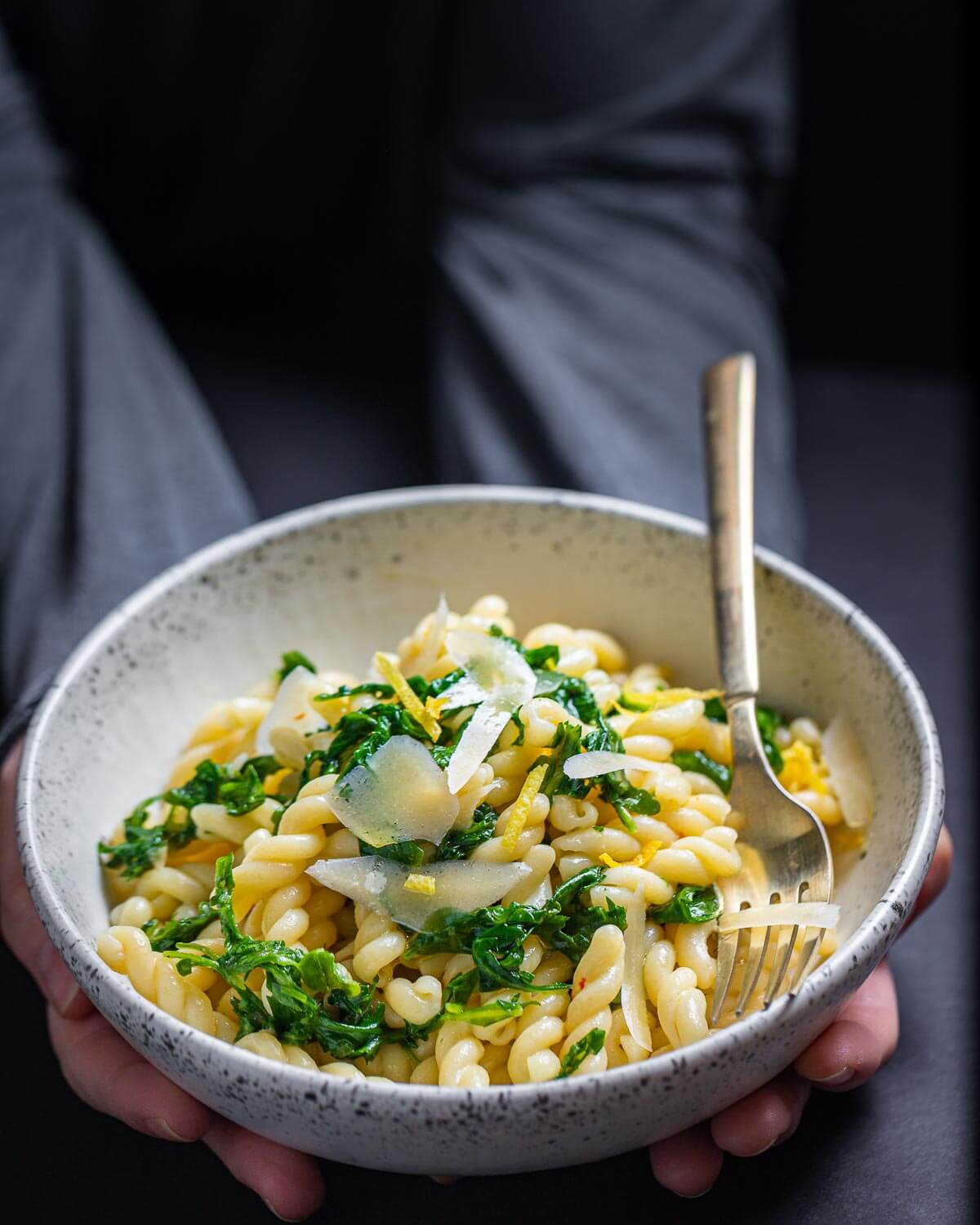 Bowl of pasta held in hands.