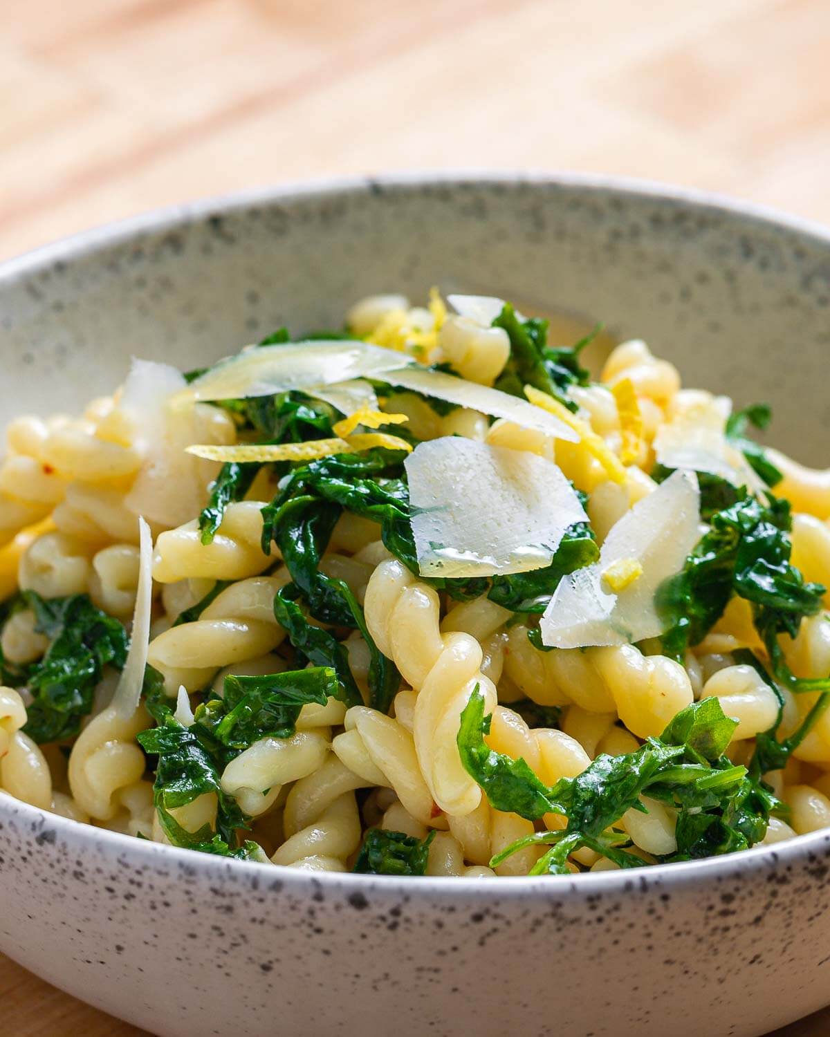 Lemon arugula pasta in white bowl.