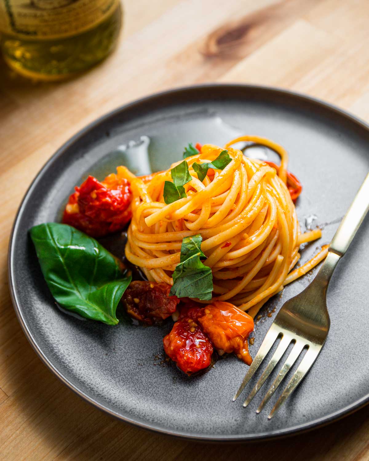 Grey plate with nest of linguine with roasted tomato sauce.