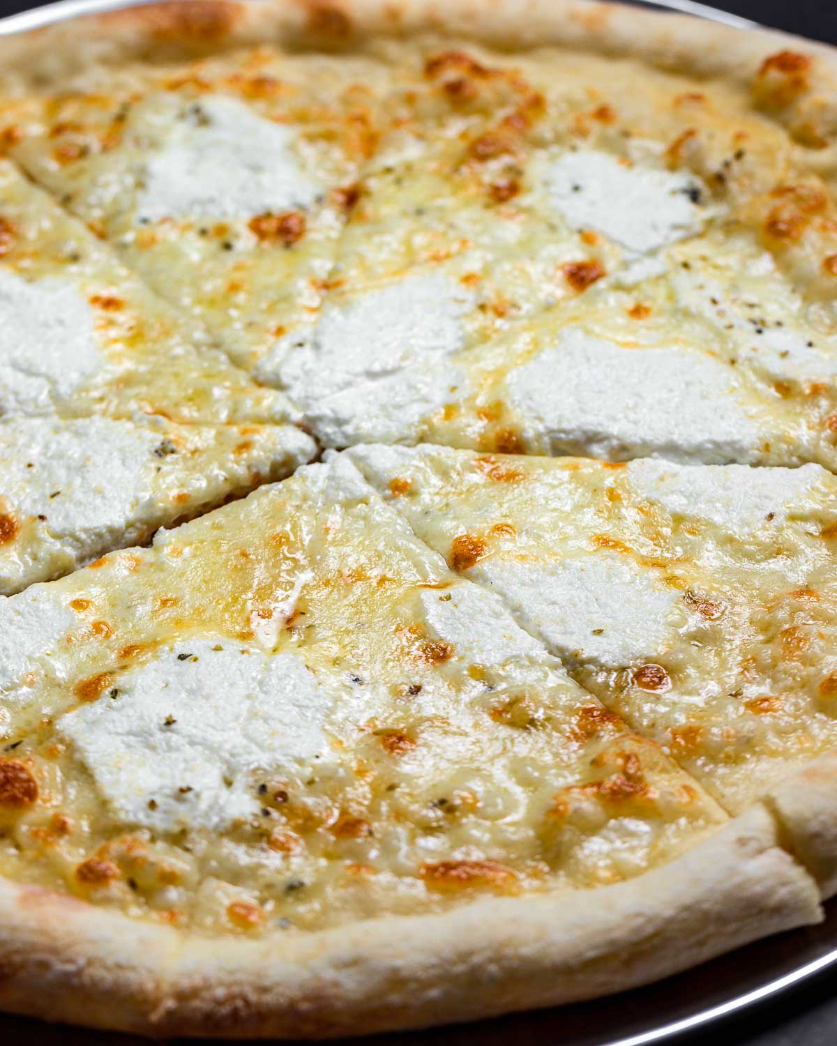 Full white pizza on pizza pan.