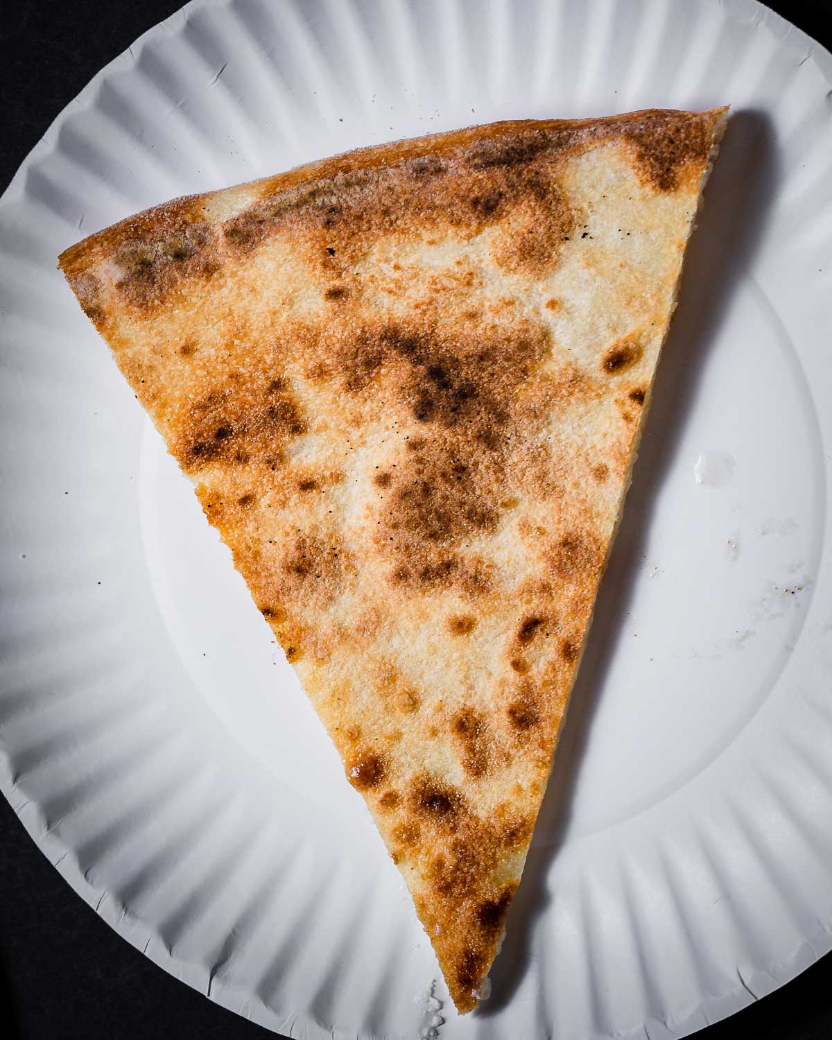 Charred bottom of pizza slice.