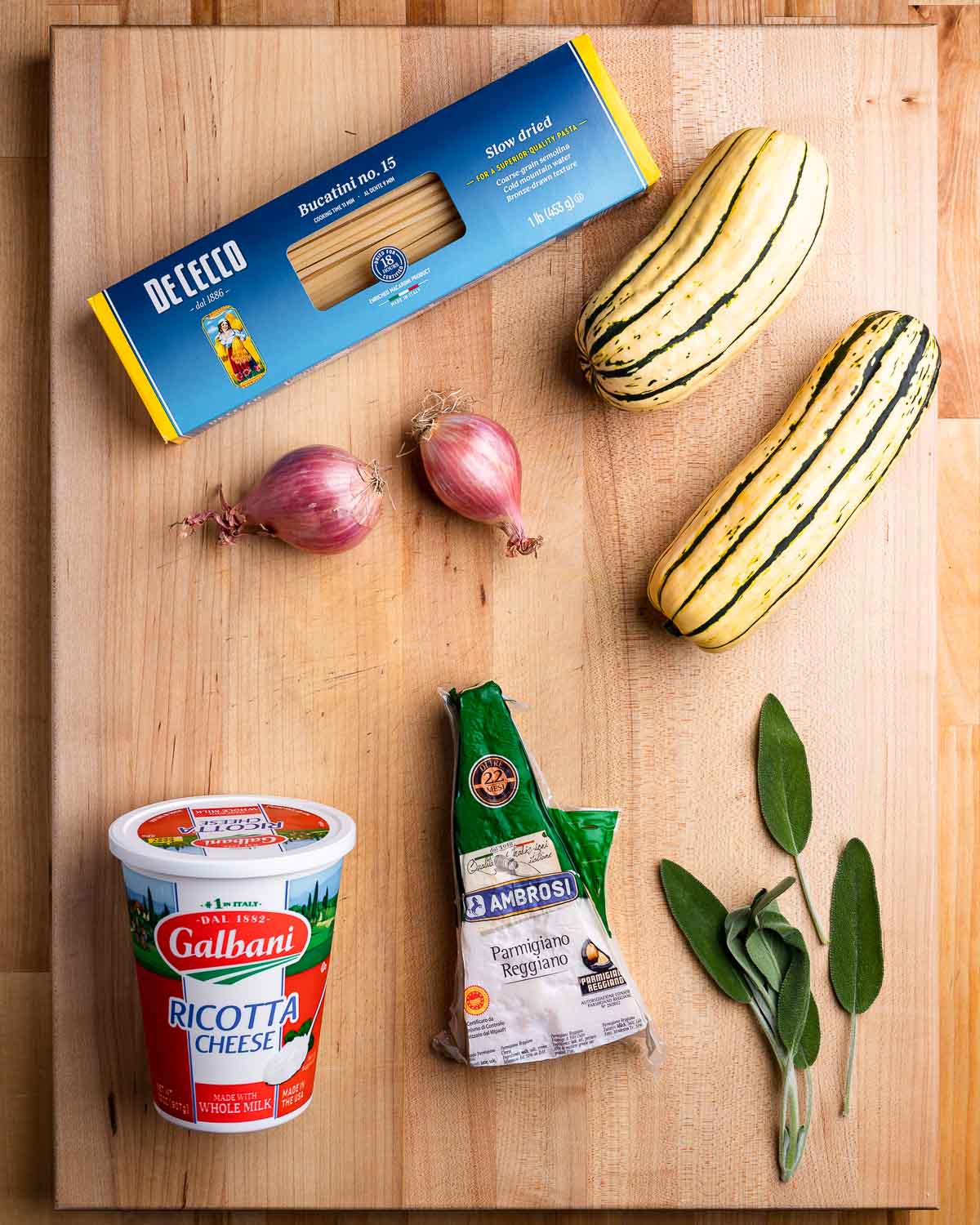 Ingredients shown: bucatini pasta, shallots, delicata squash, ricotta, parmesan, and sage leaves.
