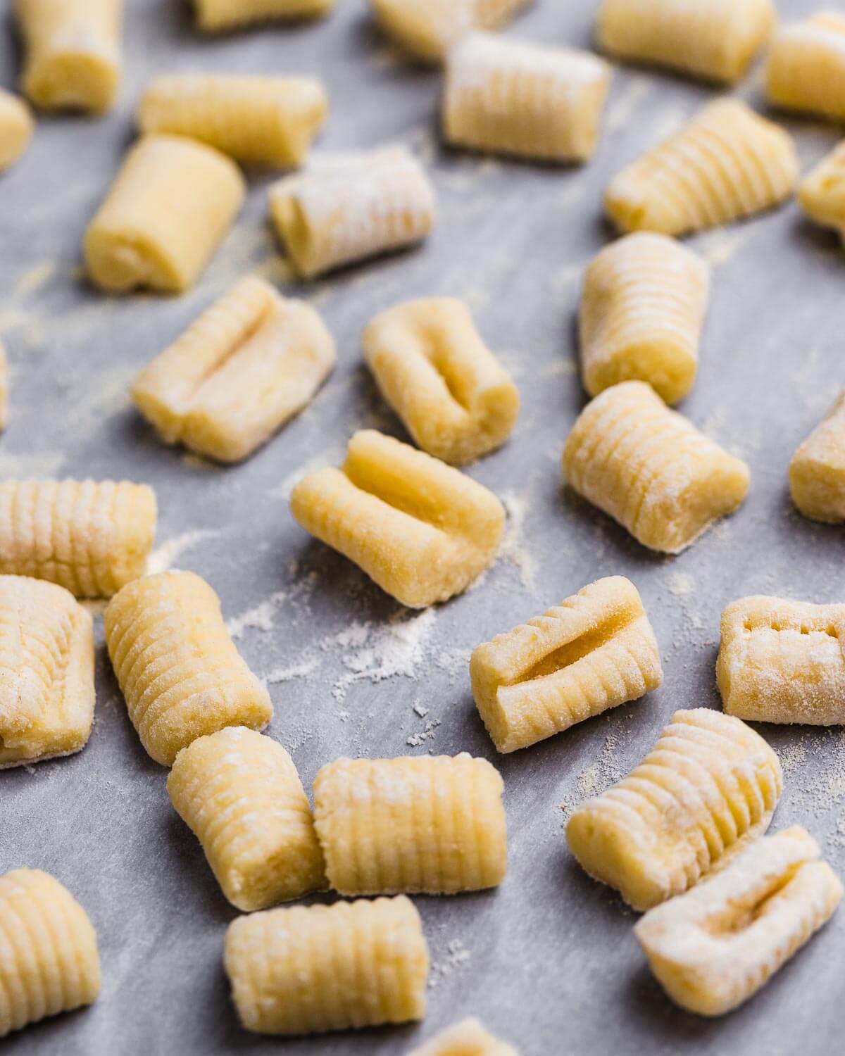 Fresh made potato gnocchi on parchment paper lined baking sheet.