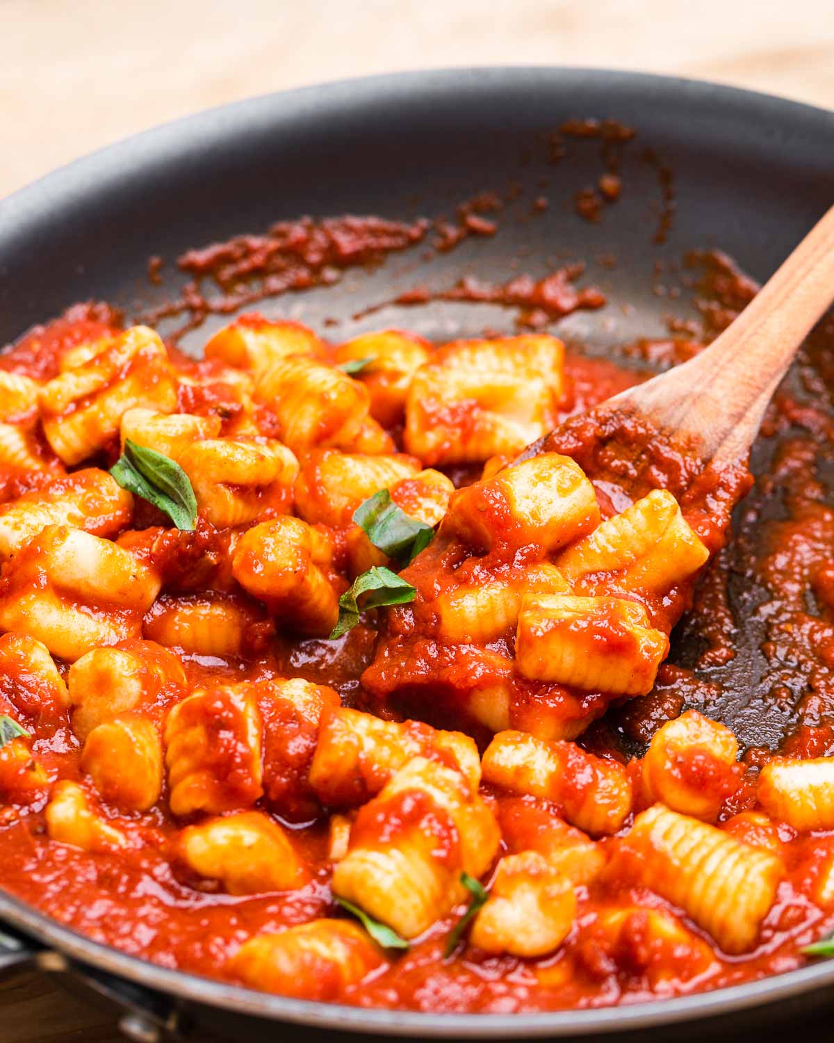 Pan of potato gnocchi with tomato sauce.