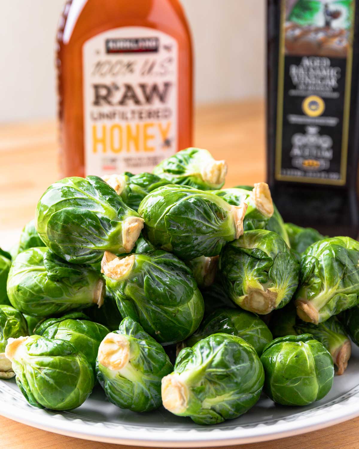 Ingredients shown: honey, balsamic vinegar, and plate of brussels sprouts.