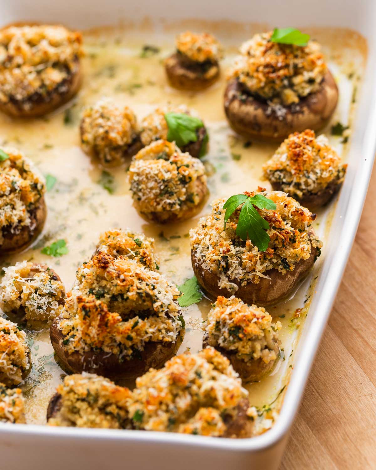 White baking dish with cooked stuffed mushrooms.