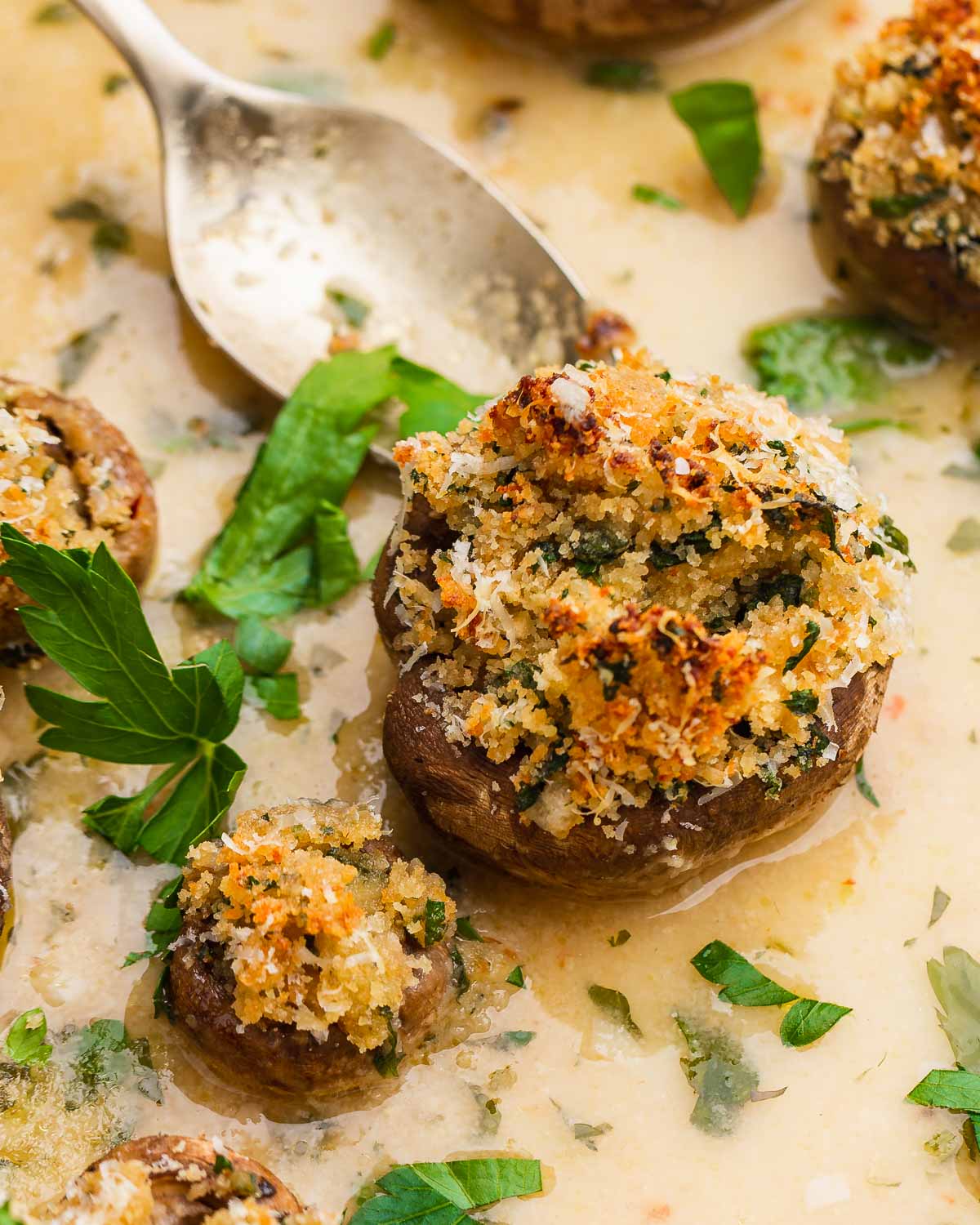 Large stuffed mushroom in dish with spoon.